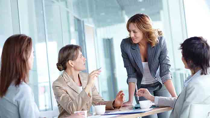 Four businesswomen discussing business in an office space.