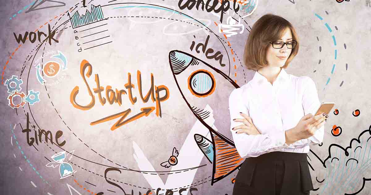 Woman standing against wall with sketches and business terms.